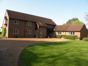 una casa de ladrillo con un césped verde delante de ella en Woodfield Self-Catering apartment, en Cambridge