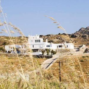 a white house on a hill with tall grass at Ftelia View in Ftelia