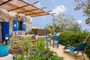 a patio with chairs and a table in a yard at The Architect's Village House in Mirsíni