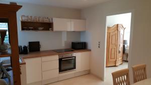 a kitchen with white cabinets and a stove at Chalet am See in Nassereith