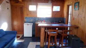 a kitchen with a counter and a table and a refrigerator at Algarrobo Suites in Algarrobo