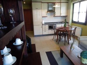 a kitchen and living room with a table and a couch at Apartamentos la Marina in Ribadesella +8 photos