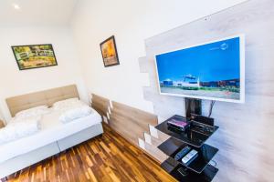ウィーンにあるVienna Market Apartments & free Garageのベッド1台、薄型テレビが備わる客室です。