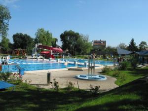 a large swimming pool with a water park at P16 Apartment in Hajdúböszörmény