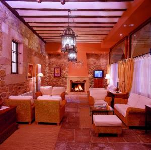 a large living room with couches and a fireplace at Hotel Palacio Guevara in Treceño