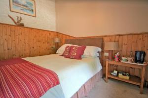 a bedroom with a bed and a table with a tv at The Old Rectory in Boscastle