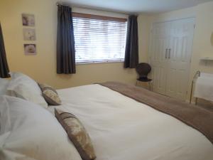 Schlafzimmer mit einem großen weißen Bett und einem Fenster in der Unterkunft Oxford Apartments 1 in Oxford