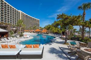 een zwembad met ligstoelen en een hotel bij The San Luis Resort Spa & Conference Center in Galveston