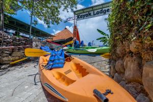 un canoë-kayak orange est garé à côté d'un bâtiment dans l'établissement Kayak Lodge, à Damas