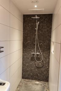 a bathroom with a shower with a stone wall at 't Rheebokje in Uddel +17 photos