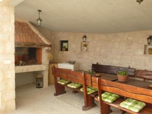 a kitchen with two benches and a stone wall at Kuća za odmor Viola in Živogošće