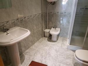 uma casa de banho com um lavatório, um WC e um chuveiro em Piso Maceira Combarro em Combarro