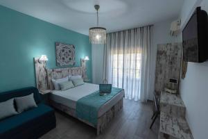a bedroom with blue walls and a bed and a couch at Blue Bay Hotel in Skala Potamias
