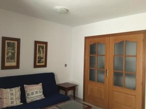a living room with a blue couch and a door at Apartamento en el centro in Ceuta