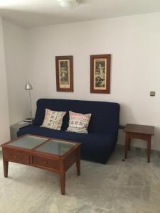 a living room with a blue couch and a coffee table at Apartamento en el centro in Ceuta