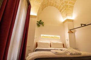 una camera con due letti e una tenda rossa di Signuria Dimora Esclusiva a Lecce