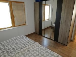 a bedroom with a bed and a large mirror at Kod Male Gospe in Tribunj