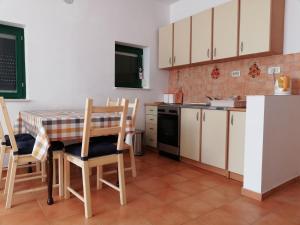 a kitchen with a table and chairs in a room at Kod Male Gospe in Tribunj