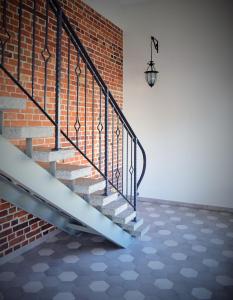 a brick stairwell with a metal railing and a brick wall at Otepää Apartments in Otepää
