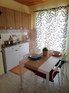 eine Küche mit einem Tisch und Stühlen mit gemusterter Wand in der Unterkunft Panoramic view studio in Rab