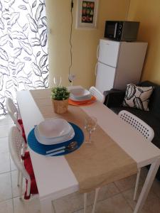einem weißen Tisch mit Platten und Platten darüber in der Unterkunft Panoramic view studio in Rab