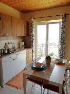 eine Küche mit einem Tisch und eine Küche mit einem Fenster in der Unterkunft Panoramic view studio in Rab
