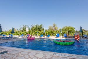 a pool with two people in inflatables in the water at Ionion Apartments & Studios in Nydri +12 photos