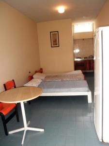 a small room with a bed and a table and a table and a tablektop at Kit's Ubatuba in Ubatuba