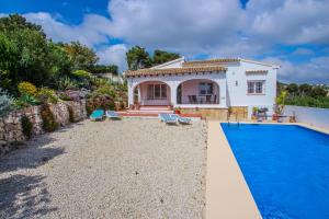 een villa met een zwembad en een huis bij Susana - this lovely detached holiday property in Moraira in Moraira