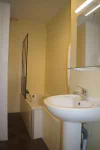 uma casa de banho com um lavatório branco e um espelho. em Hôtel Rapin em Portets