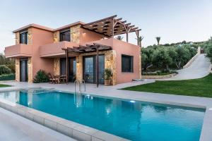 a house with a swimming pool in front of a house at Villa Kudos in Maleme