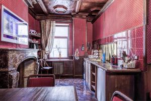 モスクワにあるuTrip Antique Redの赤い壁のキッチン、暖炉、テーブル