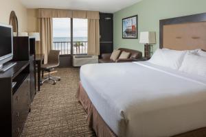 a hotel room with a large bed and a television at Holiday Inn Resort Galveston - On The Beach, an IHG Hotel in Galveston