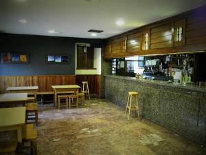 un bar con mesas y taburetes en un restaurante en Hotel Sindika en Oñate