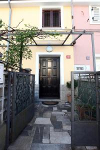 une porte noire sur une maison avec une clôture dans l'établissement Apartment Svobode Izola, à Izola