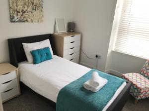 a bedroom with a bed with a pillow and a chair at Liberty House in Weston-super-Mare