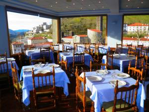 ein Restaurant mit blauen Tischen und Stühlen und Aussicht in der Unterkunft Hotel Sindika in Oñate