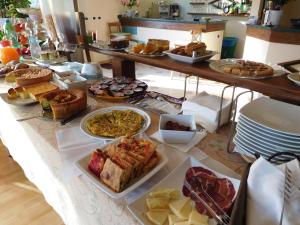 una mesa con muchos tipos diferentes de comida en ella en Hotel Michelangelo, en San Bartolomeo in Galdo