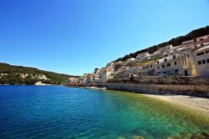 Blick auf einen Strand mit Gebäuden und Wasser in der Unterkunft Apartmani Nila in Pučišća