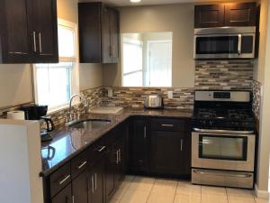 a kitchen with a sink and a stove top oven at Newly Renovated 2 Bedroom House in Seaside Heights