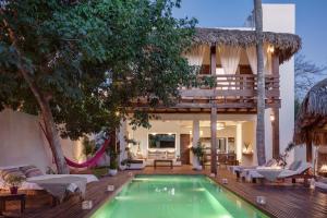 a villa with a swimming pool and a house at Villa Métisse in Jericoacoara