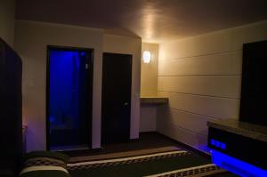Habitación con puerta con luz azul en Motel Encuentro en Tijuana