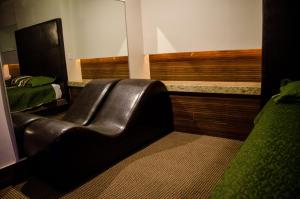 a leather couch in a room with a bed at Motel Encuentro in Tijuana