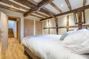 a bedroom with a large bed and wooden ceilings at The Stables and Hayloft in Ledbury