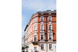 wysoki czerwony budynek z białymi oknami na ulicy w obiekcie Apartament Golden Place w Krakowie