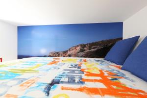 a bed with a colorful comforter on top of it at Big Wave Apartment in Nazaré