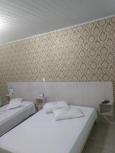 two beds in a room with a wall at Cumbipar King Hotel in Guarulhos