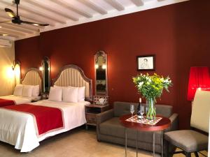 a hotel room with two beds and a couch at Casa Italia Luxury Guest House - Adults Only in Mérida