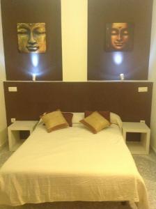Hostal Neptuno في قصرش: غرفة نوم مع سرير مع قناعين على الحائط