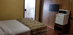 
a bedroom with a television and a bed at Mountain View Inn Yreka CA in Yreka
